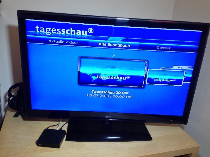 Der kleine Roku-Kasten (links unten) holt die Tagesschau per Fernbedienung auf unseren Fernsehkasten.