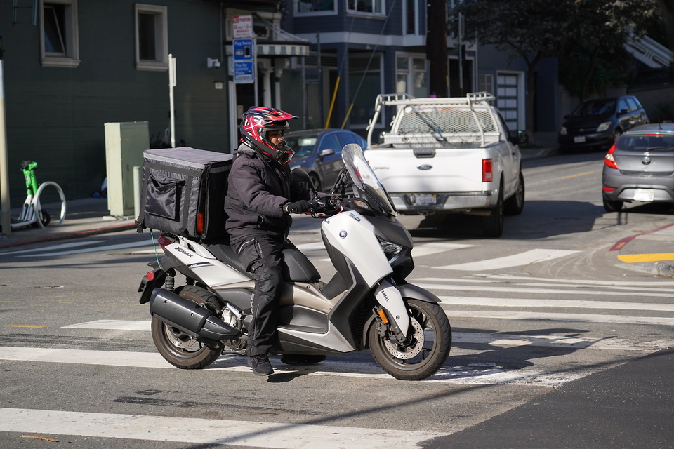 Der Mopedfahrer vom Bringdienst rast kreuz und quer durch die Stadt.