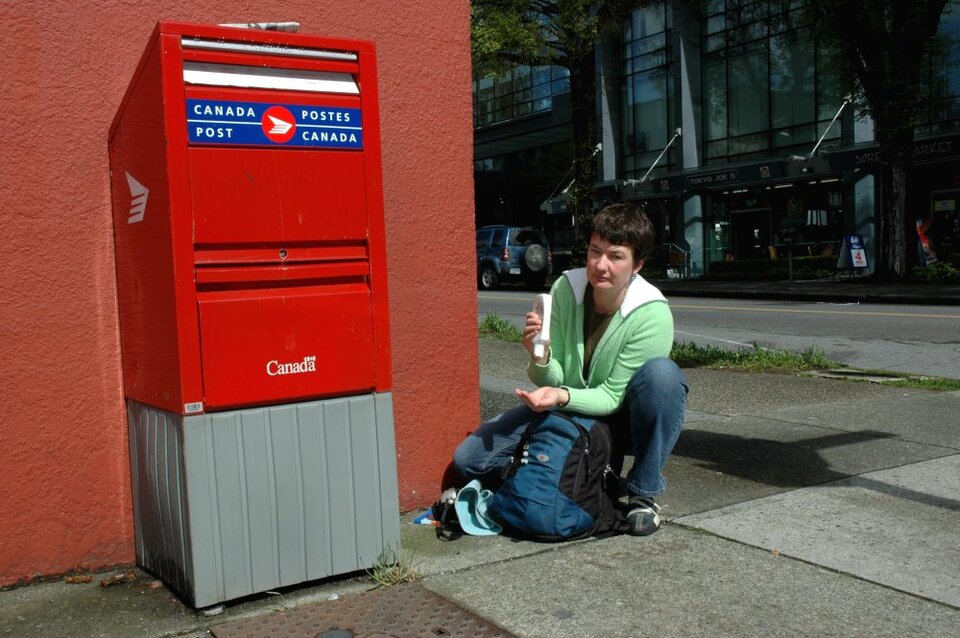 2005: Angelika presst an einem kanadischen Briefkasten Sonnenmilch aus der Flasche.